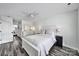 Bright bedroom with a white dresser, a ceiling fan, a bed with neutral linens, and wood-look floors at 901 Heritage Pkwy, Fort Mill, SC 29715