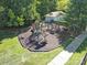 Community playground area surrounded by trees and green space near a building and sidewalks at 901 Heritage Pkwy, Fort Mill, SC 29715