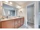 Bathroom with double vanity, framed mirror, wood cabinets, and doorway to toilet room at 985 Angelica Ln, Tega Cay, SC 29708