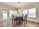 Bright dining area features stylish lighting, hardwood floors, and a door to the outdoor space at 985 Angelica Ln, Tega Cay, SC 29708