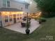 Backyard with concrete patio, outdoor furniture, string lights, and well-manicured lawn at dusk at 985 Angelica Ln, Tega Cay, SC 29708