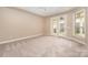 Bedroom with neutral carpet, white ceiling fan and trim, and access to the backyard at 1008 Avalon Pl, Matthews, NC 28104