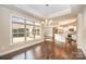 Charming dining room with hardwood floors, chandelier, and a view of the modern kitchen and living spaces at 1008 Avalon Pl, Matthews, NC 28104