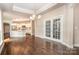 Open dining area with hardwood floors and a view to a modern kitchen through decorative glass doors at 1008 Avalon Pl, Matthews, NC 28104