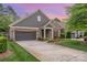 Charming single-Gathering home boasts stone and siding accents, a two-car garage, and manicured landscaping at 1008 Avalon Pl, Matthews, NC 28104
