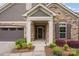 Close-up of the stone-faced front entrance showcasing the covered porch and manicured landscaping at 1008 Avalon Pl, Matthews, NC 28104