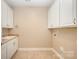 Clean and functional laundry room with ample cabinet space, a sink, and tile flooring at 1008 Avalon Pl, Matthews, NC 28104
