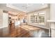 Open-concept living area featuring hardwood floors, fireplace, kitchen, and large windows providing ample sunlight at 1008 Avalon Pl, Matthews, NC 28104