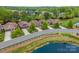 A row of well-maintained houses lines a street with beautiful landscaping near a pond at 1008 Avalon Pl, Matthews, NC 28104