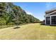 Spacious backyard featuring lush green grass and mature trees, creating a serene outdoor space at 1052 Harlow'S Crossing Dr, Weddington, NC 28104