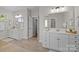 Bathroom with separate vanities with white cabinetry, quartz counters, and views to the exterior at 1052 Harlow'S Crossing Dr, Weddington, NC 28104