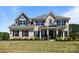 Stunning brick two-story home with a manicured lawn and charming front porch at 1052 Harlow'S Crossing Dr, Weddington, NC 28104