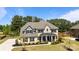 Elegant brick home with a covered porch, manicured landscaping, and inviting curb appeal at 1052 Harlow'S Crossing Dr, Weddington, NC 28104