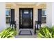 Inviting front porch with a stylish black door, rocking chairs, and lush ferns at 1052 Harlow'S Crossing Dr, Weddington, NC 28104