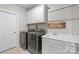 Well-equipped laundry room with modern appliances, storage cabinets, and a sink, providing convenience and functionality at 1052 Harlow'S Crossing Dr, Weddington, NC 28104