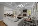 Open-concept living room boasts coffered ceilings, a stone fireplace, and hardwood floors, seamlessly connecting to the kitchen at 1052 Harlow'S Crossing Dr, Weddington, NC 28104