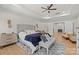 Well-lit primary bedroom with tray ceiling, hardwood floors, a sitting area, and an ensuite bathroom at 1052 Harlow'S Crossing Dr, Weddington, NC 28104