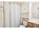 Bathroom features a white cabinet, toilet, and shower with a decorative white curtain at 12027 Stratfield Place Cir, Pineville, NC 28134