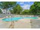 Community pool with lounge chairs, lush landscaping, and secure fencing at 12027 Stratfield Place Cir, Pineville, NC 28134