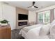 Comfortable main bedroom featuring a fireplace, TV, ceiling fan, and lots of natural light at 1313 Loggerhead Dr, Lancaster, SC 29720