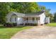 Charming single-story home featuring a quaint front porch, white siding, and well-maintained landscaping at 1325 Red Oaks Dr, Rock Hill, SC 29730