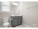 Powder room with modern vanity, toilet, and window at 137 Brawley Woods Ln, Mooresville, NC 28115