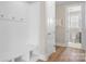 White mudroom with wainscoting, bench, hooks, and wood floors at 137 Brawley Woods Ln, Mooresville, NC 28115