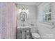 Bright bathroom featuring a pedestal sink, toilet, and window for natural light at 14855 Nc 801 Hwy Hwy, Mt Ulla, NC 28125
