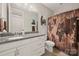 Well-lit bathroom featuring a granite countertop, white cabinetry, and a decorative shower curtain at 1501 Riverwalk Pkwy, Rock Hill, SC 29730