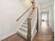 Elegant staircase with carpeted steps, a wooden handrail, and hardwood floors below at 1501 Riverwalk Pkwy, Rock Hill, SC 29730