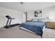 Carpeted bedroom featuring a large bed with a blue quilt and exercise equipment to the side at 15127 Oleander Dr, Charlotte, NC 28278
