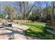 Lush backyard with a stone patio, green lawn, and mature trees, ideal for outdoor entertaining at 1751 Merriman Ave, Charlotte, NC 28203