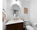 Elegant half bath featuring vanity with marble top, stylish fixtures, decorative mirror, and pristine white walls at 1751 Merriman Ave, Charlotte, NC 28203