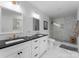 Sleek bathroom featuring double sink vanity with black countertops and luxurious marble tiled shower at 1751 Merriman Ave, Charlotte, NC 28203