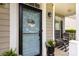Charming front porch featuring a modern light blue door, a decorative wreath, and cozy outdoor seating at 2012 Galty Ln, Charlotte, NC 28270