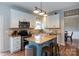 Well-lit kitchen with white cabinets, granite countertops, stainless steel appliances and kitchen island with bar stool seating at 2012 Galty Ln, Charlotte, NC 28270