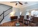 Bright living area featuring hardwood floors, a staircase, and a glimpse into the dining and kitchen areas at 2012 Galty Ln, Charlotte, NC 28270
