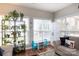 Bright, plant-filled living room with a comfortable couch, a white armoire, and large windows allowing natural light at 2012 Galty Ln, Charlotte, NC 28270