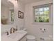 Bright bathroom with marble countertop vanity, white cabinets, and a window providing natural light at 218 Kimrod Ln, Charlotte, NC 28270