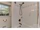 Tiled shower with a hand shower, a grab bar, and a window offering natural light at 218 Kimrod Ln, Charlotte, NC 28270