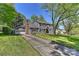 Traditional two-story home with an attached garage and a long driveway, surrounded by mature trees at 218 Kimrod Ln, Charlotte, NC 28270