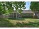 A fenced backyard offers a screen porch, mature trees and lush green space at 2415 Tory Oak Pl, Matthews, NC 28105