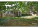 A fenced backyard offers a screen porch, mature trees and lush green space at 2415 Tory Oak Pl, Matthews, NC 28105