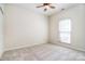 This bedroom offers neutral carpeting, a ceiling fan, natural light from a window and closet at 2415 Tory Oak Pl, Matthews, NC 28105