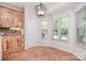 Bright breakfast nook featuring tiled floors, wooden cabinets, and a modern light fixture at 2415 Tory Oak Pl, Matthews, NC 28105