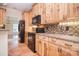 Kitchen with wood cabinets, black appliances, tile floors, and a tile backsplash at 2415 Tory Oak Pl, Matthews, NC 28105