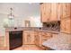 Kitchen with wood cabinets, granite counters, and black appliances at 2415 Tory Oak Pl, Matthews, NC 28105