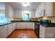 Well-lit kitchen featuring white cabinets, black countertops, and hardwood floors at 2540 Heritage Cir, Statesville, NC 28625