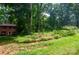 Brick home nestled amongst mature trees and surrounded by lush greenery and a well-maintained lawn at 2540 Heritage Cir, Statesville, NC 28625