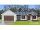 Stunning new home with white siding, stone accents, and a covered front porch at 28647 Nc Hwy 73 Hwy, Albemarle, NC 28001